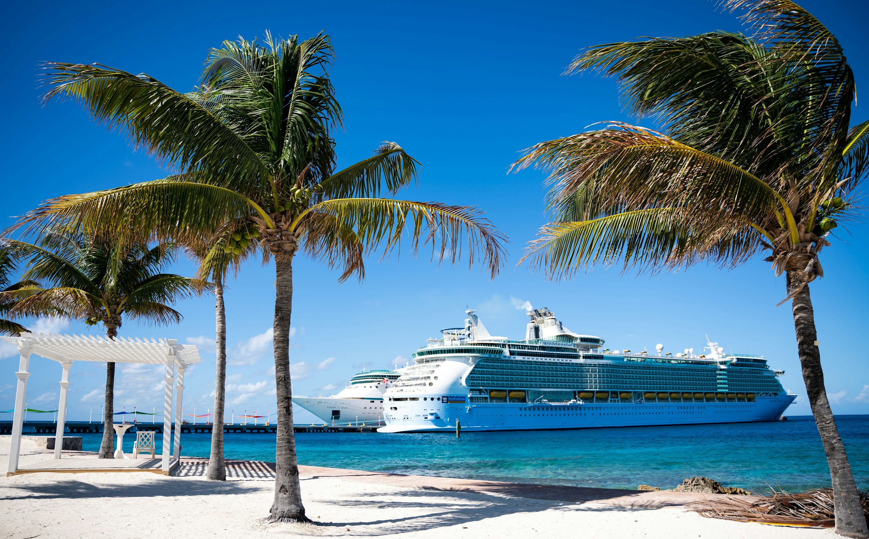 Cruise ship docked beside a tropical island beach